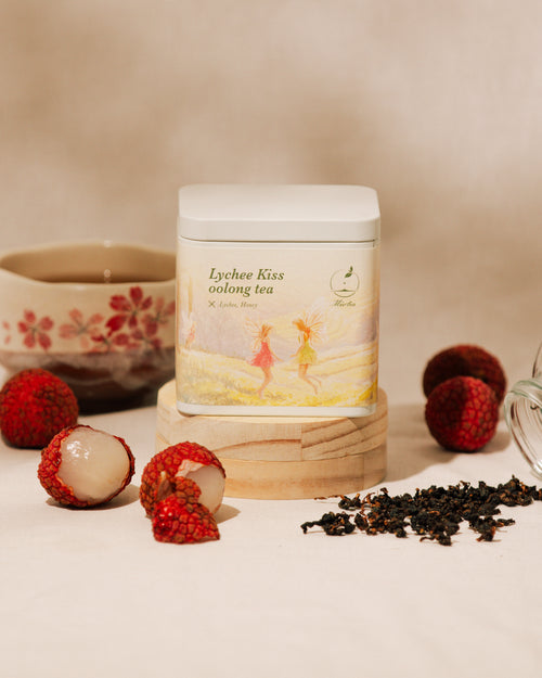 Brewed Lychee Kiss Oolong Tea with loose tea leaves and flower petals.