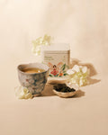 Kinsen Oolong Tea tin with brewed oolong tea and loose tea leaves.