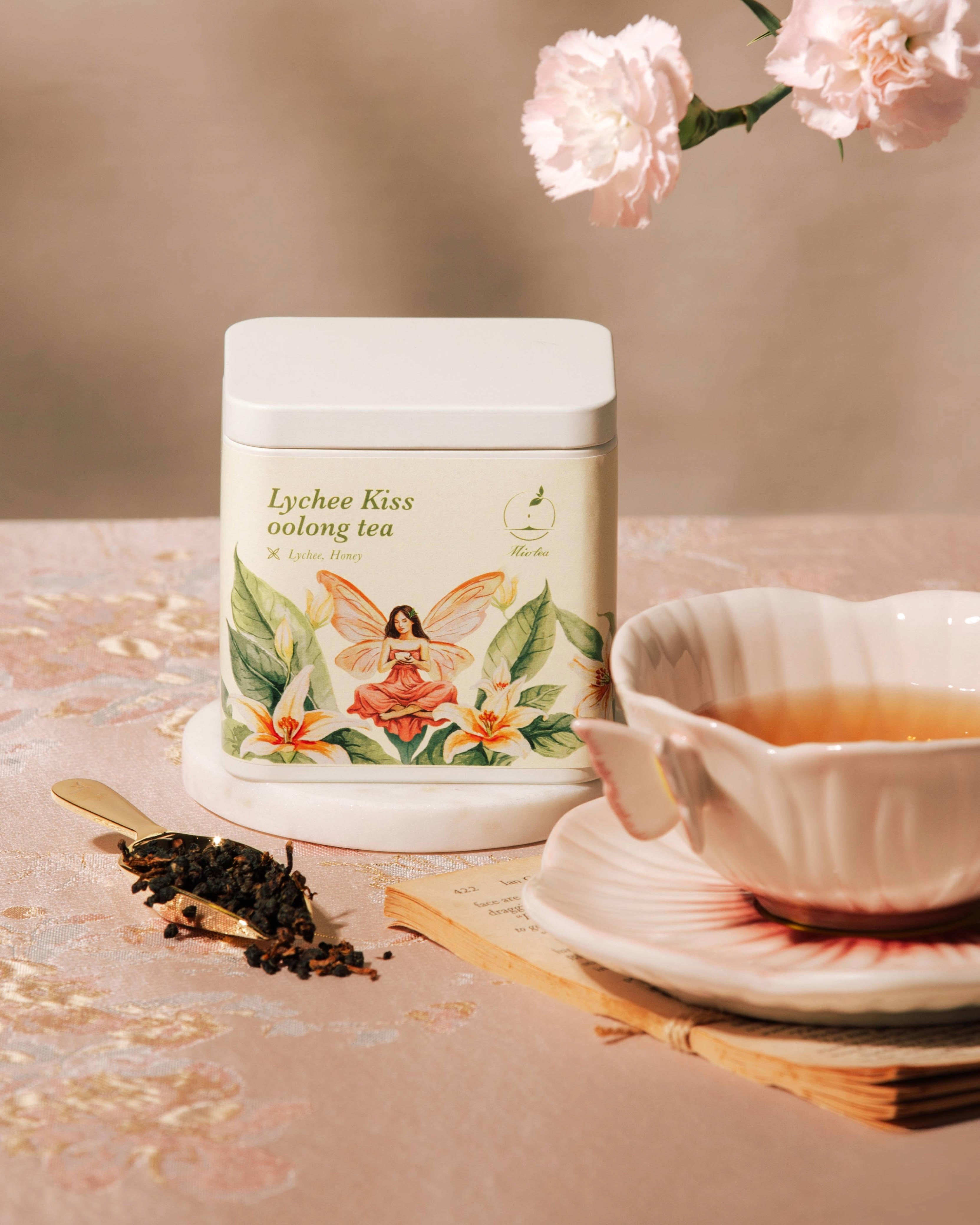 Lychee Kiss Oolong Tea tin beside a brewed cup of oolong tea.